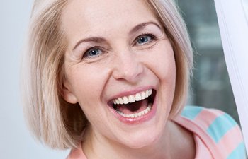 senior woman with dental implants smiling