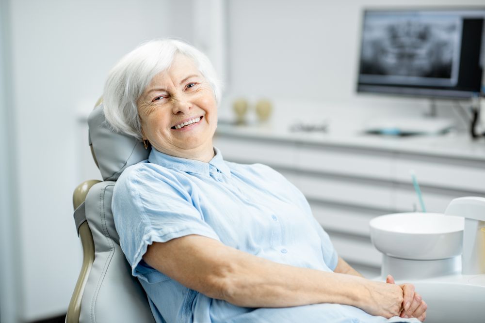 Happy smiling senior woman sitting in a dental chair.