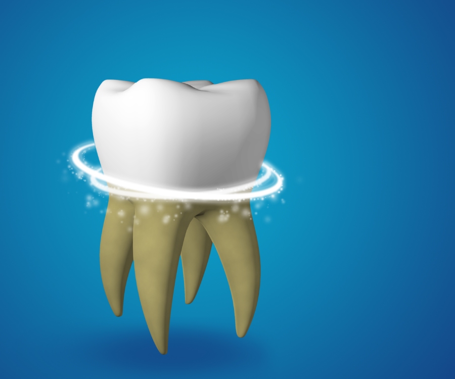 A white tooth with yellow roots is shown against a blue background, surrounded by a glowing, swirling ring near the base.